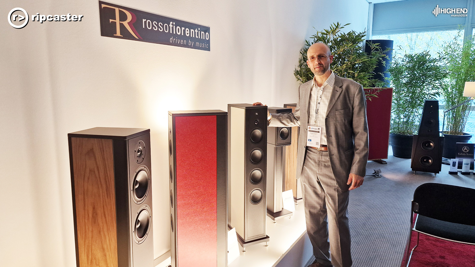 A man standing beside a range of Rosso speakers all lined up beside each other