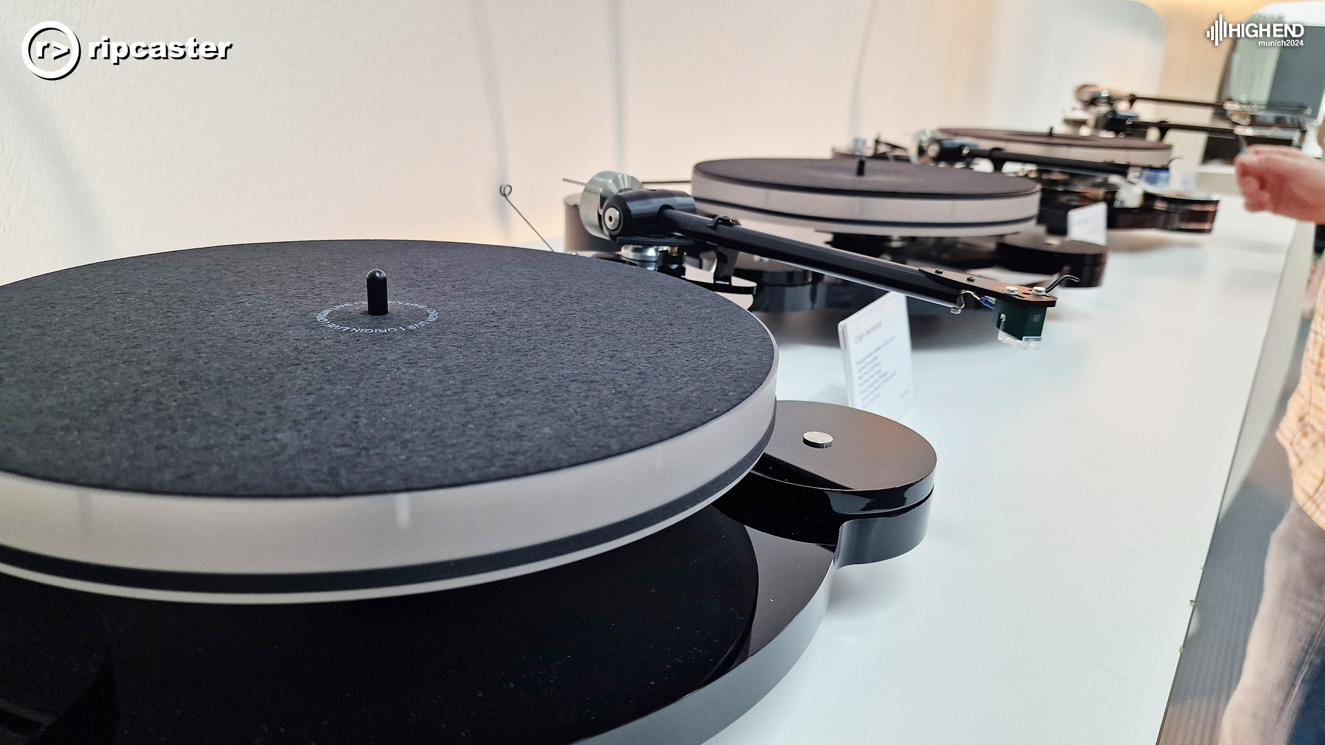 A variety of turntables lined up on a long side unit