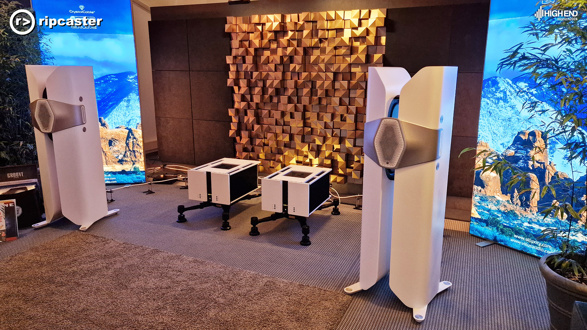 Two large floor standing speakers in white.  They resemble large pegs.  Between them are two HiFi units on stands.