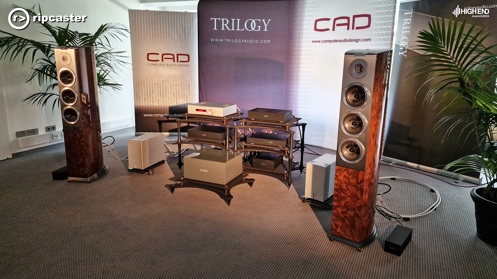 Trilogy.  A pair of floorstanding speakers with audio equipment on stands between them.