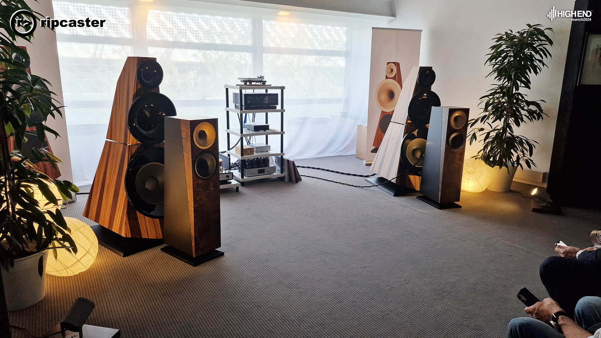 Two pairs of floorstanding speakers with other HiFi equipment between them.
