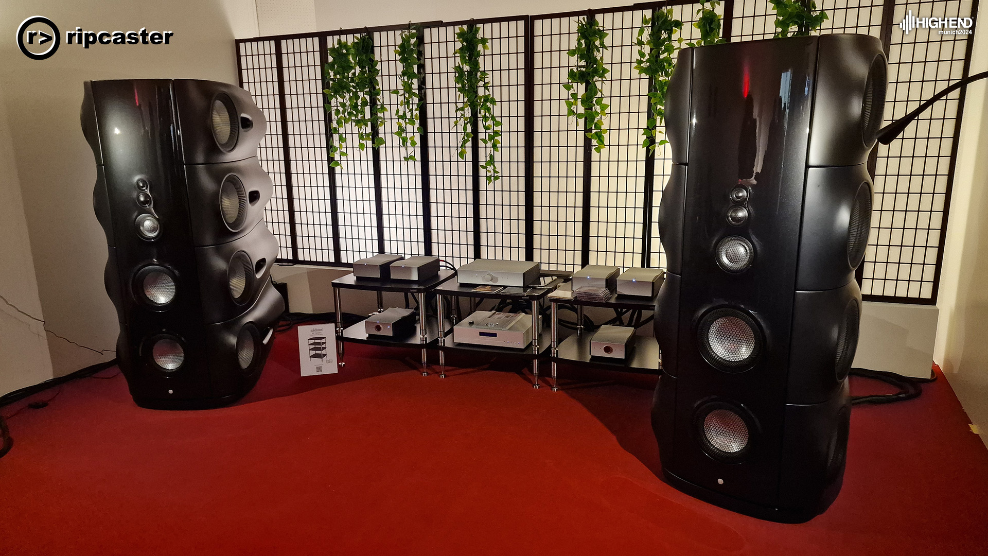 Two large black floorstanding speakers with HiFi equipment between them.