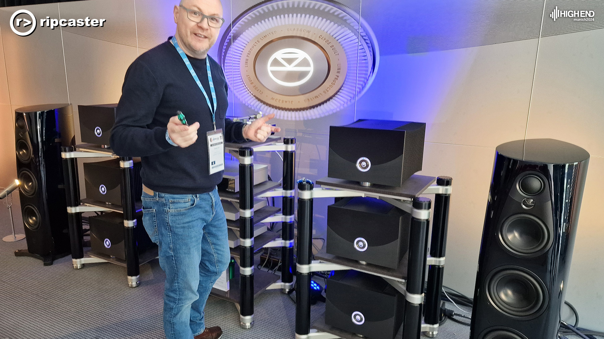 A man standing in front of stacks of Linn kit with a 360 speaker on either side of the image.