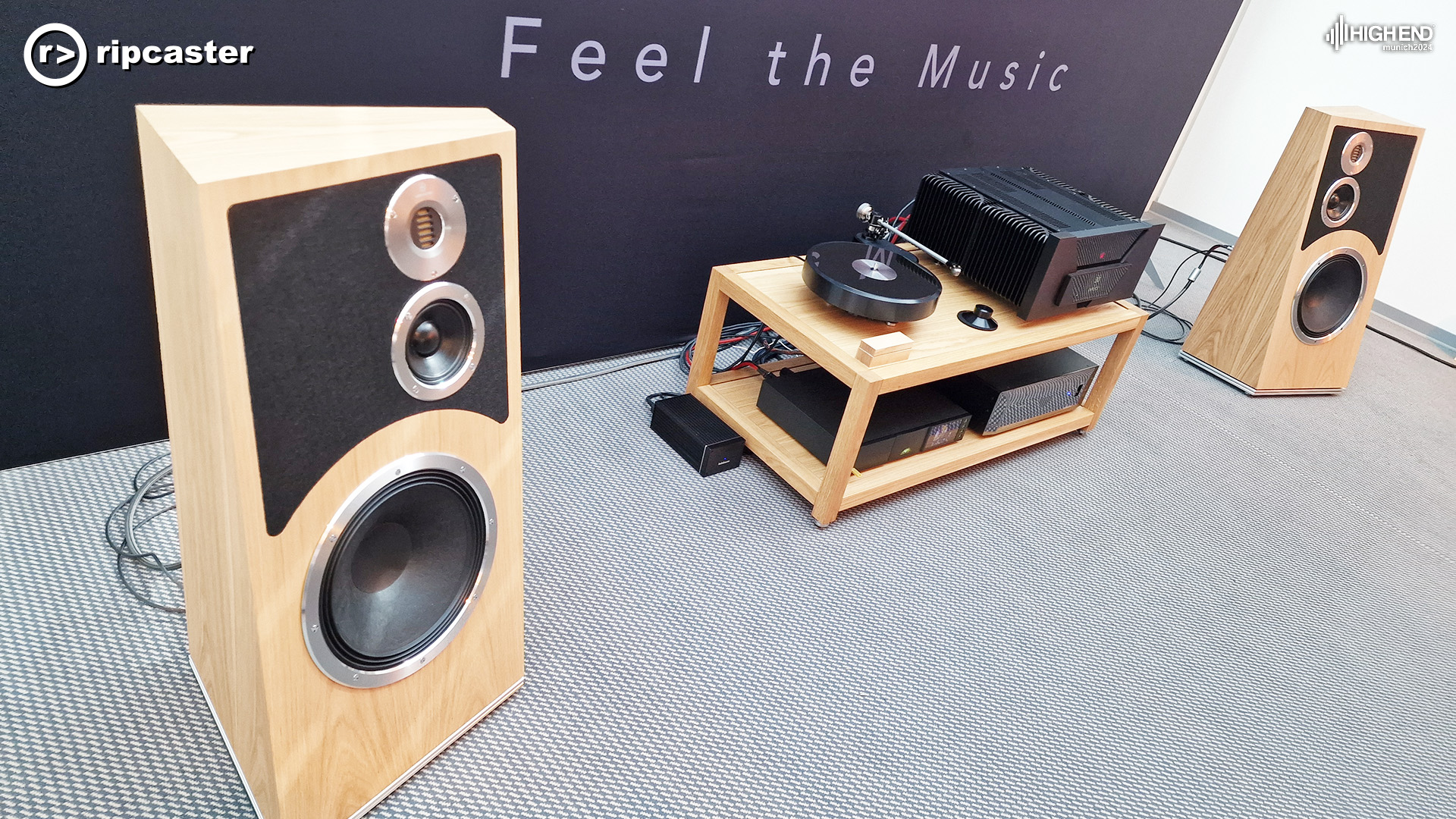 A pair of wooden speakers with a low unit between them that has a turntable and other HiFi equipment on it.