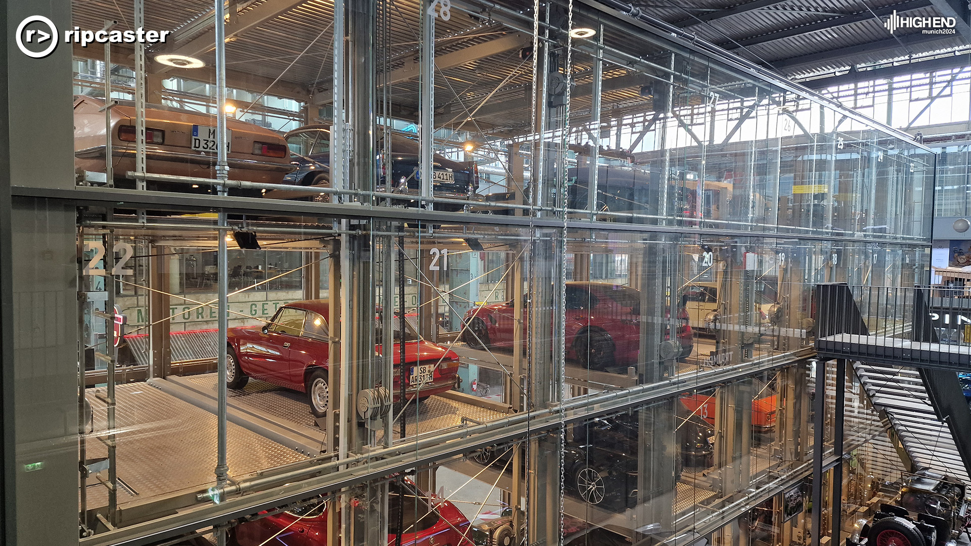 Vintage cars in a thing that looks like a massive glass cabinet.