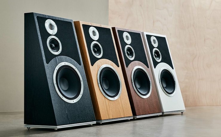 Four Audiovector Trapeze Ri speakers lined up beside each other.  One in each of the finishes.