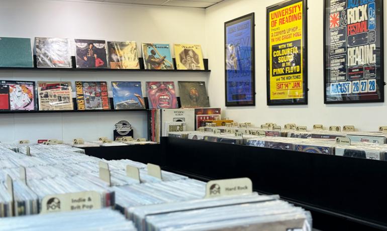 A lot of vinyl displayed ready to flick through and records on the back wall on shelves displayed front facing out.  On the right wall are large music related posters