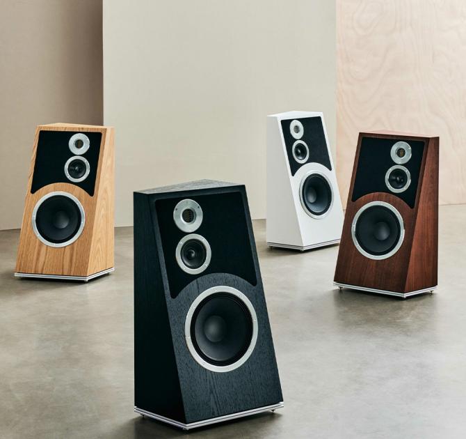 Four Audiovector Trapeze Ri speakers - one in each colour oriented differently in a large space