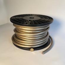 A reel of K60 cable photographed on a plain background with a pound coin to help with scale.