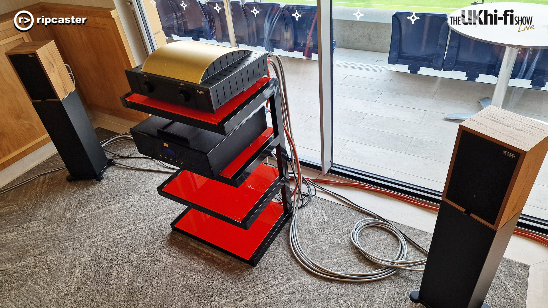 A pair of speakers either side of a HiFi equipment stand