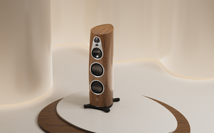 The Linn 360 speaker in walnut in a light beige coloured room on a low platform with walnut edging 