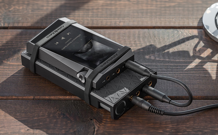 Astell & Kern AKPA10 Portable Class-A Amplifier strapped to an A&K player on a wooden table