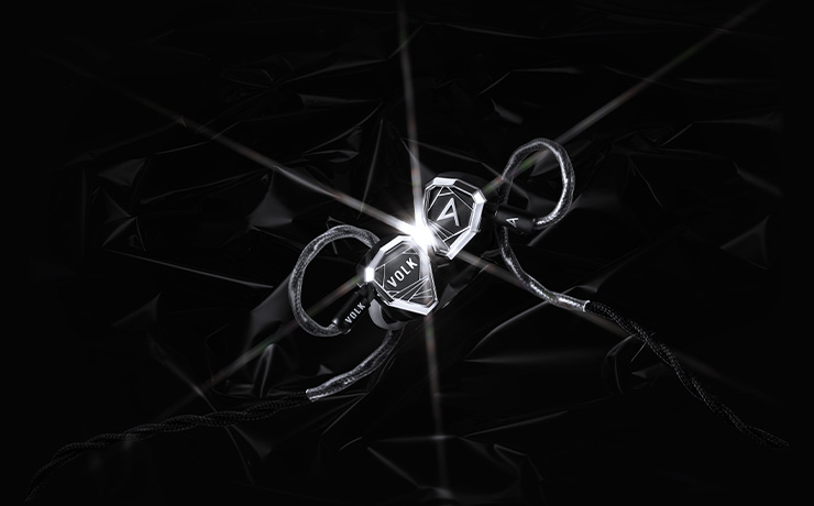 Astell & Kern Stella earphones on a black background with a light flare in the centre of the image