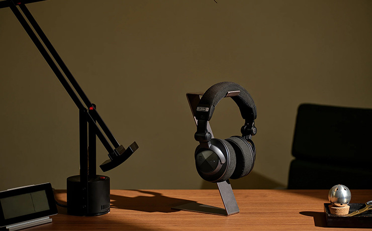 Astell & Kern Virtuoso Headphones on a desk with a lamp beside it