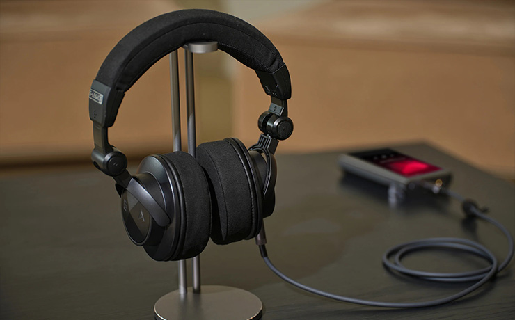 Astell & Kern Virtuoso Headphones on their stand with a player beside it