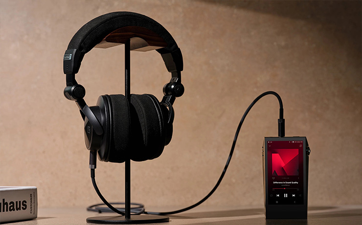 Astell & Kern Virtuoso Headphones on a stand with a player