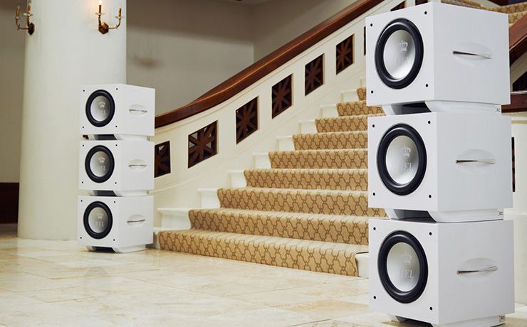 Six REL subwoofers stacked in two groups of three either side of a wide staircase.