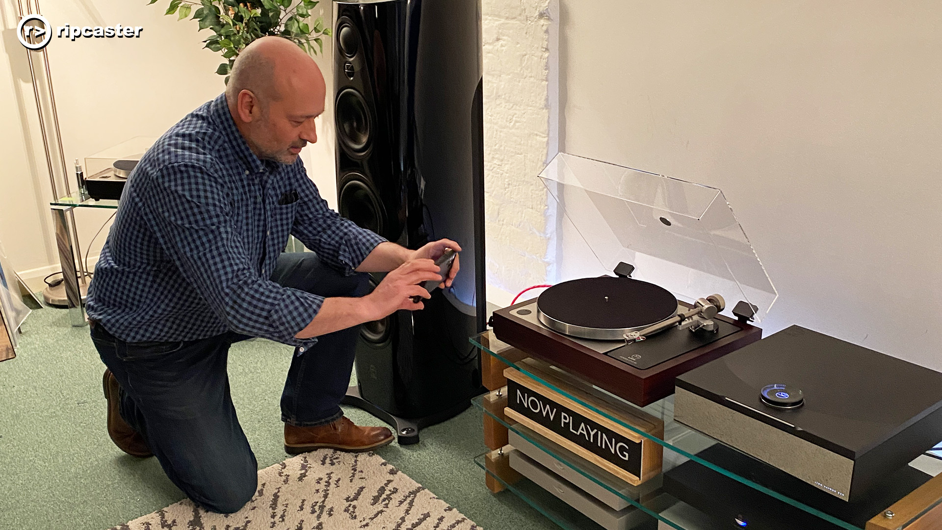 A man kneeling taking a photo of the Linn LP12-50