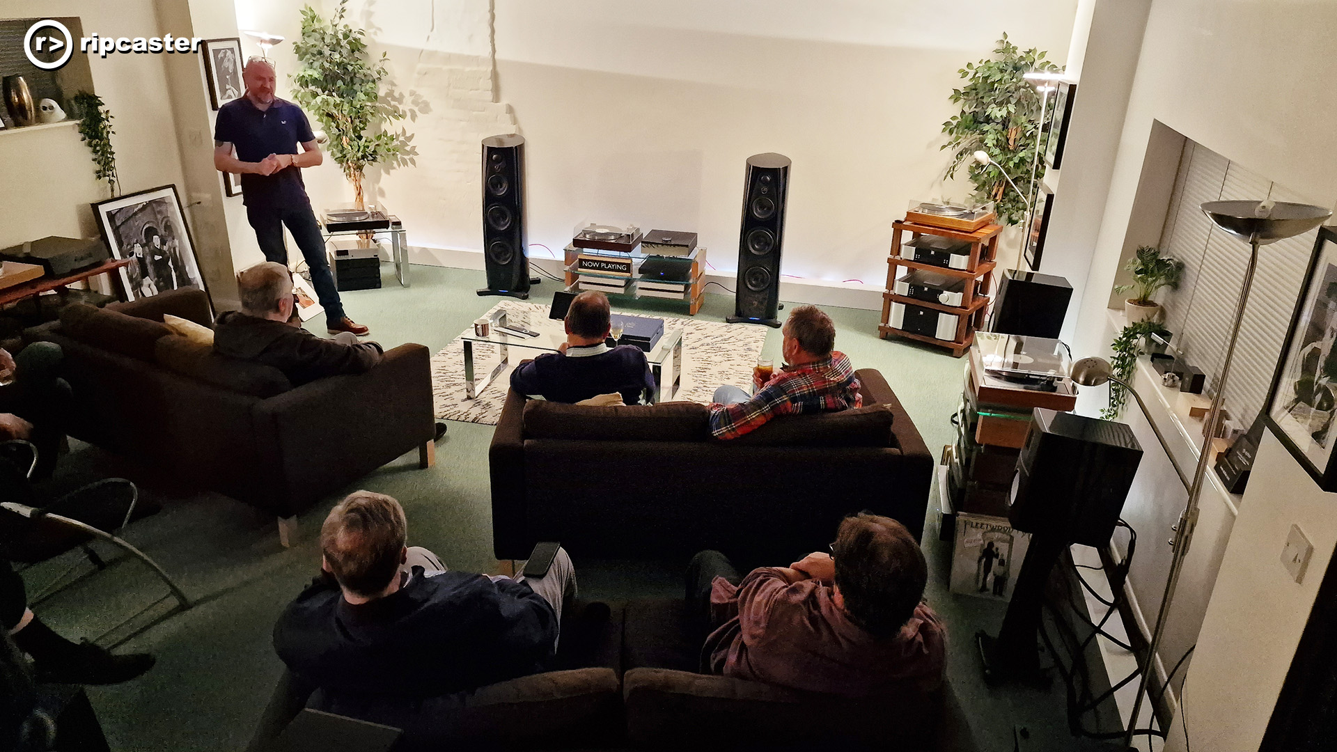 a room full of people listening to a talk about Linn HiFi equipment.  The HiFi equipment is at the front of the room.