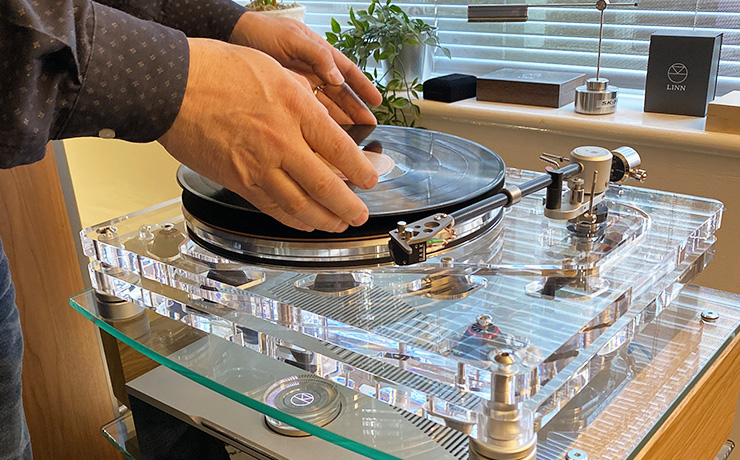 Vertere MG-1 MKII Magic Groove Turntable in our ripcaster showroom with a man's hands putting a recording onto the turntable