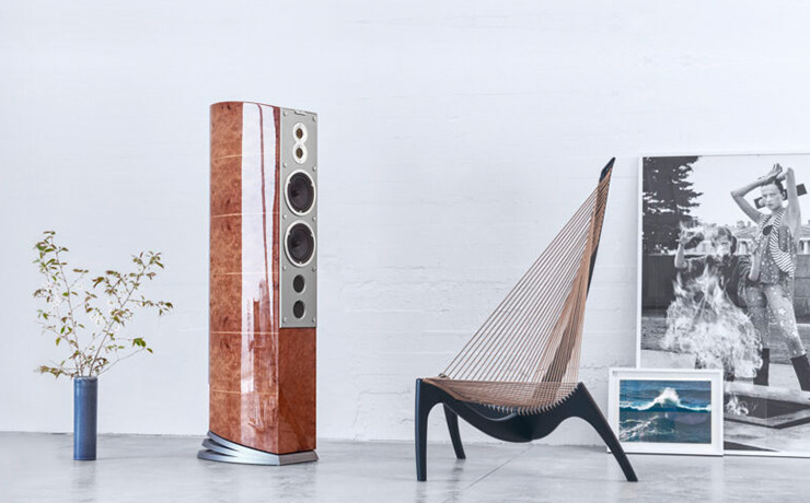 Audiovector R11 speaker beside a chair that has a back resembling a harp - lots of strings