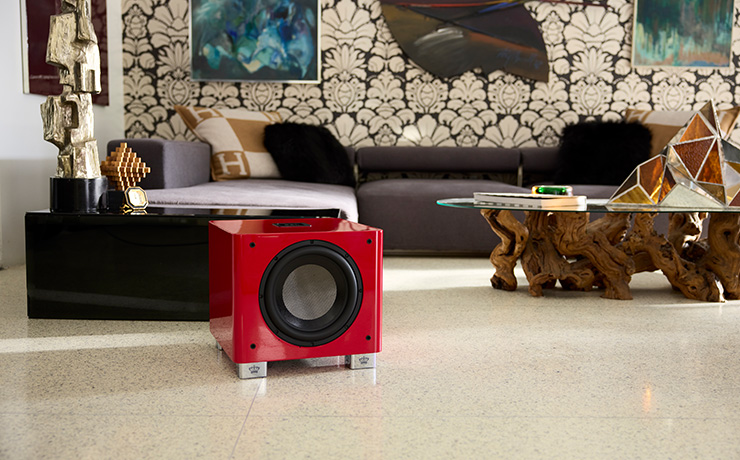 A red REL T/9x sub on the floor of a modern living space