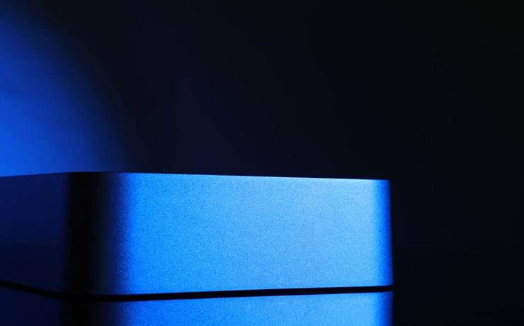 The Silent Angel Rhein with blue lighting. It's a small silver box shape with rounded corners