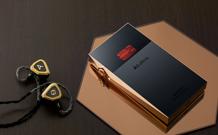 Astell & Kern A&ultima SP3000T Copper Edition Portable Music Player laying face-down beside some earphones on a table