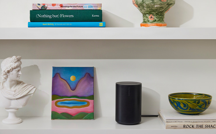 Sonos Era 100 SL in black on a shelf with other objects
