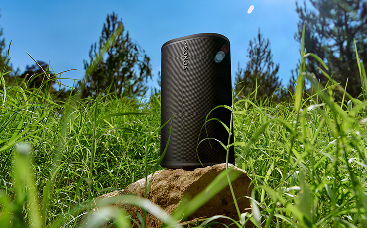 The Sonos Play in black in a field of grass with blue sky
