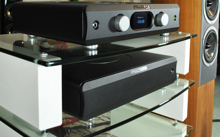 Ultrafide U4PRE Audiophile Pre-Amplifier on top of a HiFi Rack with an Ultrafide U500DC on the shelf below and a floorstanding Audiovector speaker beside it