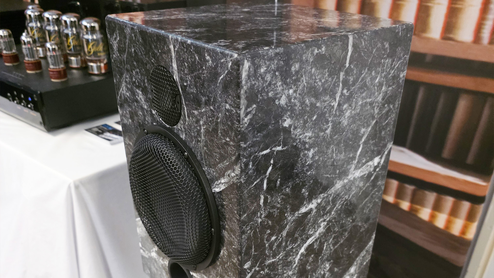 A bookshelf speaker on a stand.  The speaker has a stone effect finish that reminds me of marble.  It's black and white