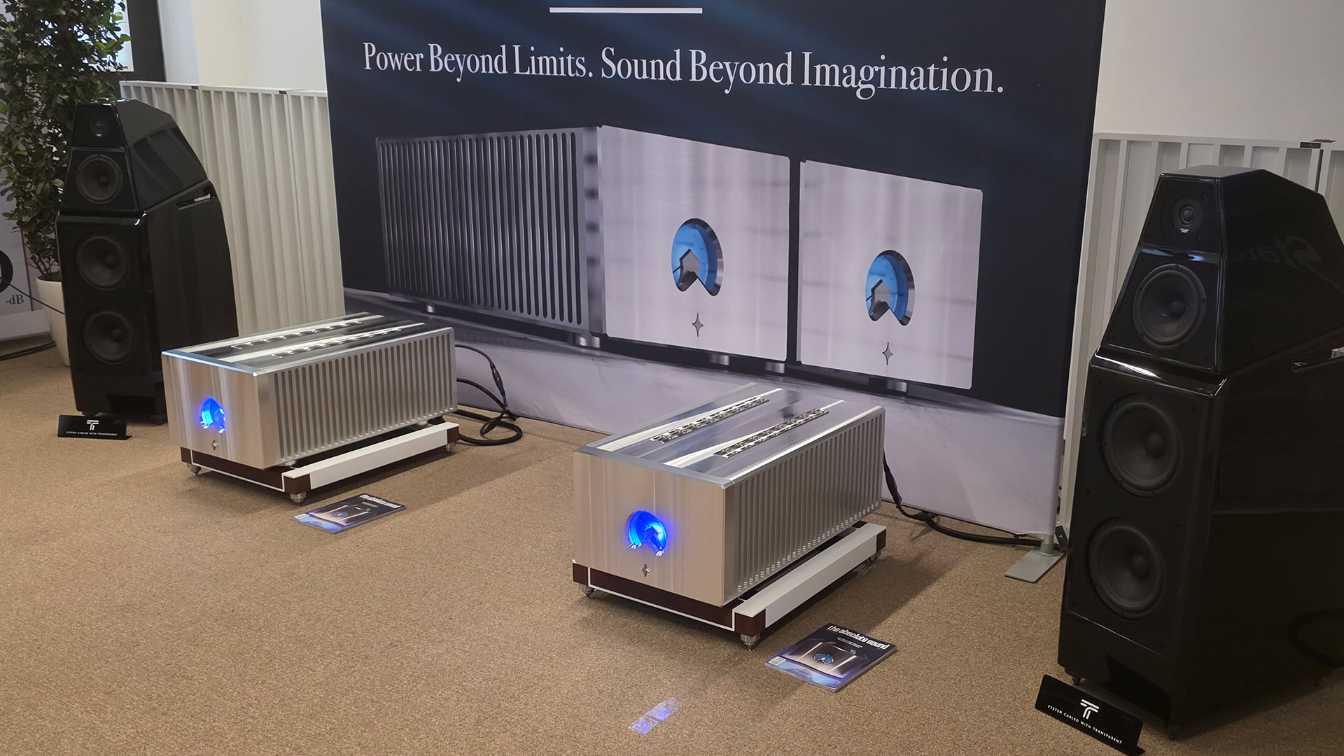 Two large floorstanding speakers in black with chrome HiFi equipment in between them