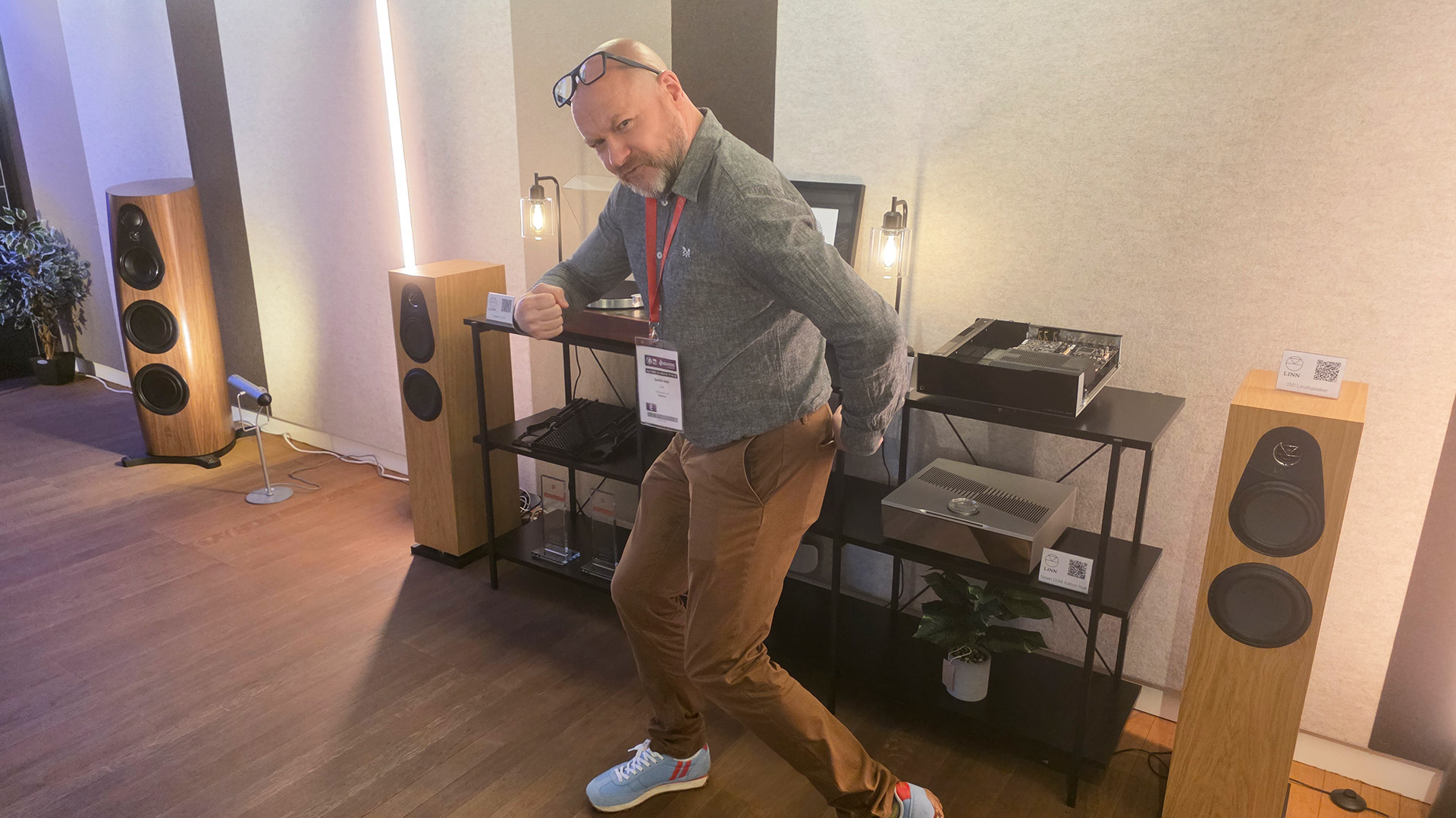Gordon from Linn posing to the side with his glasses on his head among the Linn products
