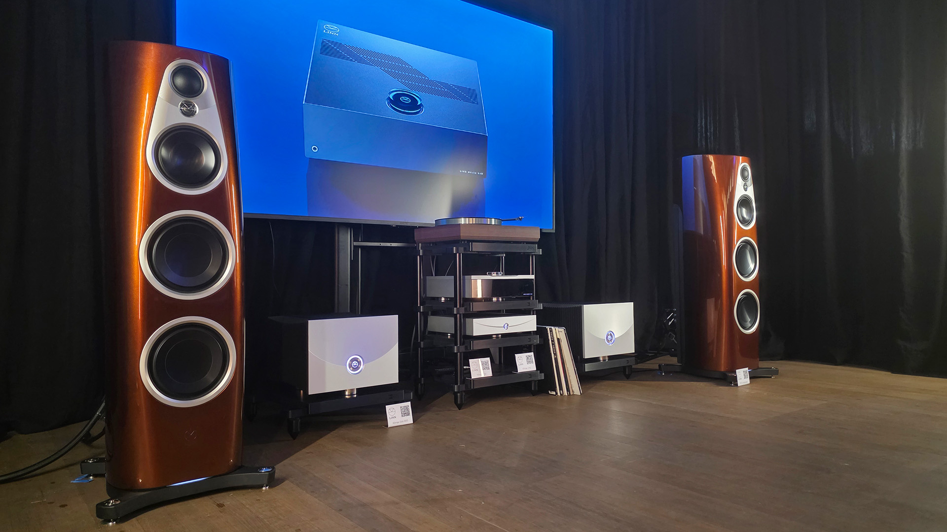 A pair of 360 speakers in the single malt finish with a stack of Linn products inbetween along with a pair of Linn 800s 