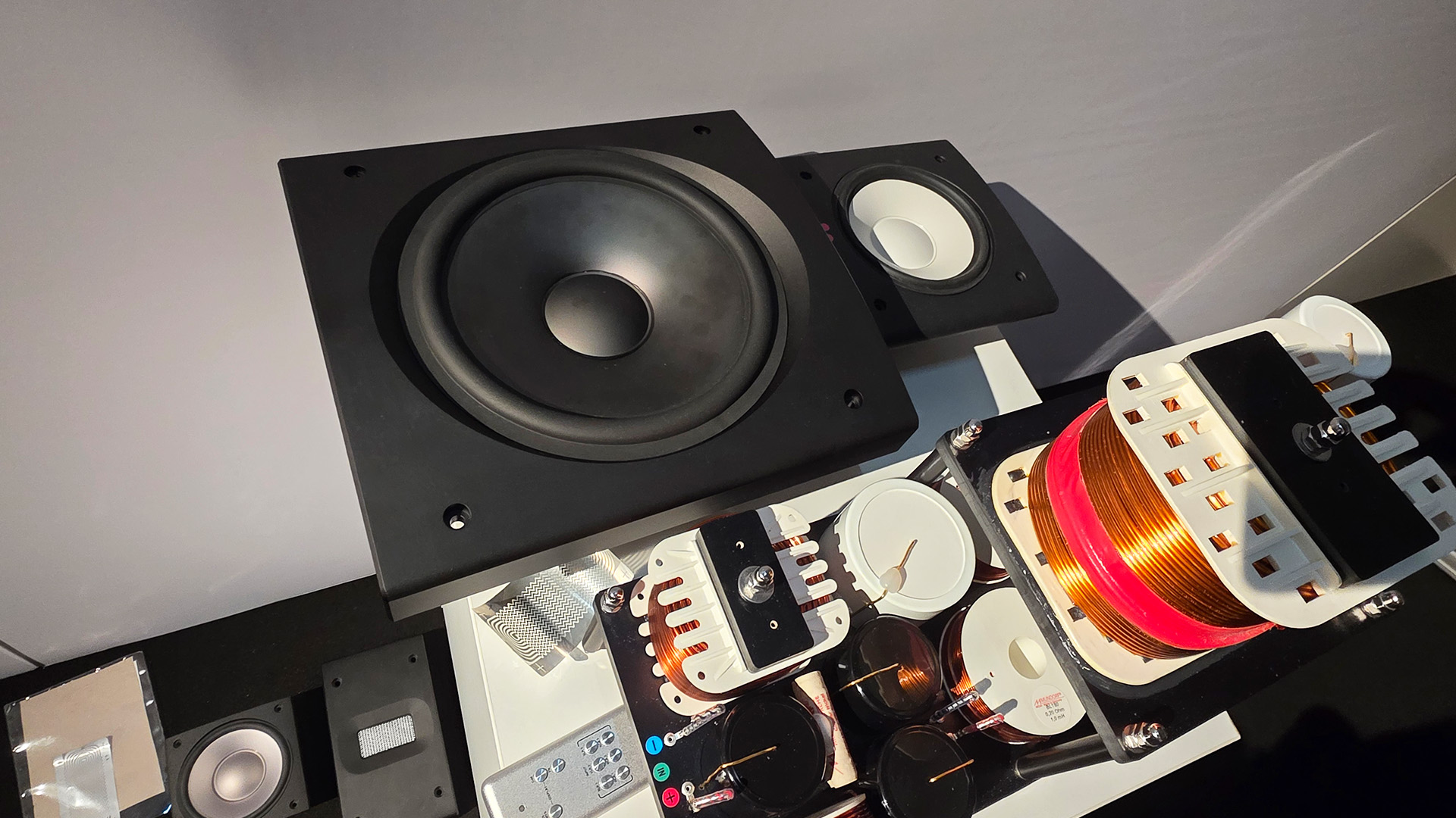 A selection of coils and a remote control along with a view of the front of the speaker