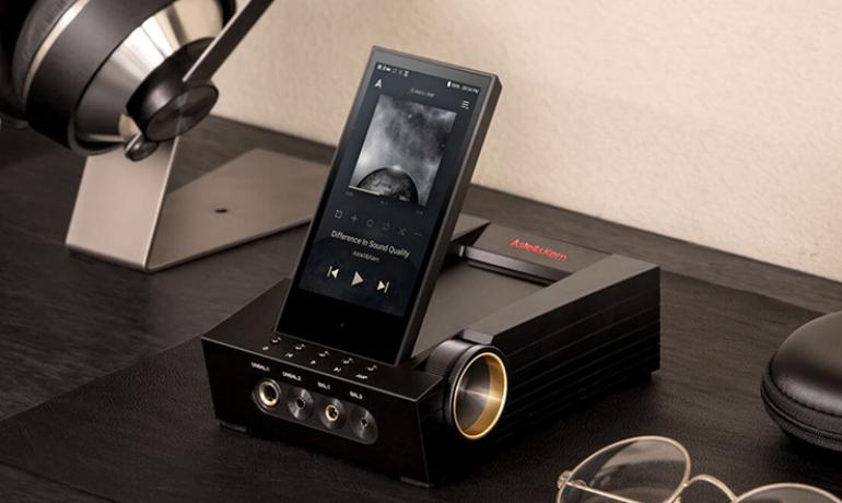 The Astell & Kern ACRO CA1000T on a table with some partially visible headphones