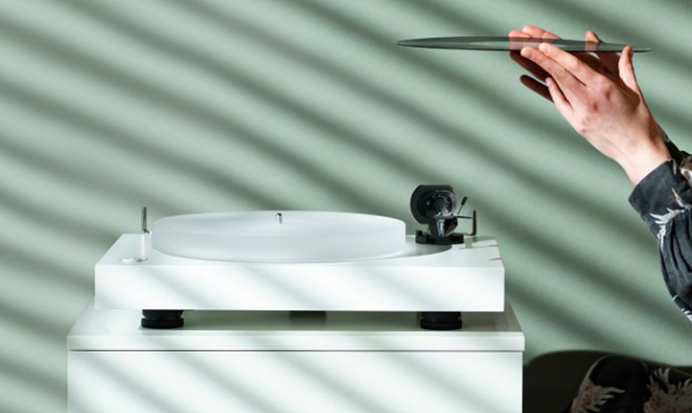 A woman inspecting a record before placing it on the X2 turntable