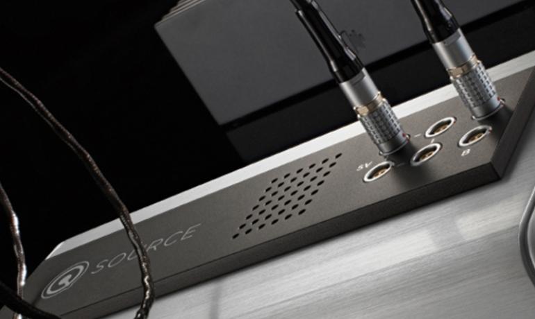 Nordost QSOURCE close-up on a dark background with cables plugged in