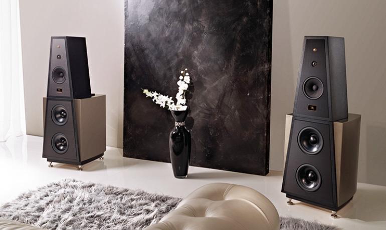 A pair of Rosso Fiorentino Siena II loudspeakers in a room with a beige rug