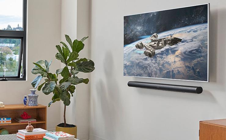 Sonos Arc Ultra in black mounted underneath a wall mounted TV screen.