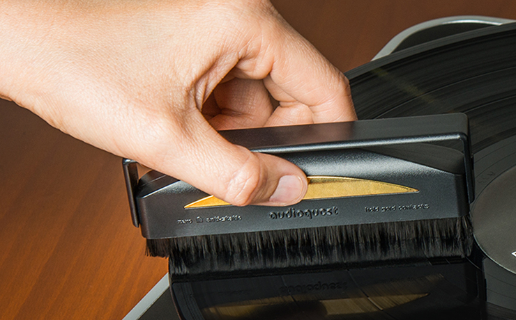 AudioQuest Super-Conductive Anti-Static Record Brush being held and cleaning a record.