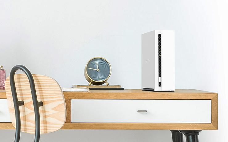 QNAP TS-133 NAS Storage on a desk with a clock beside it