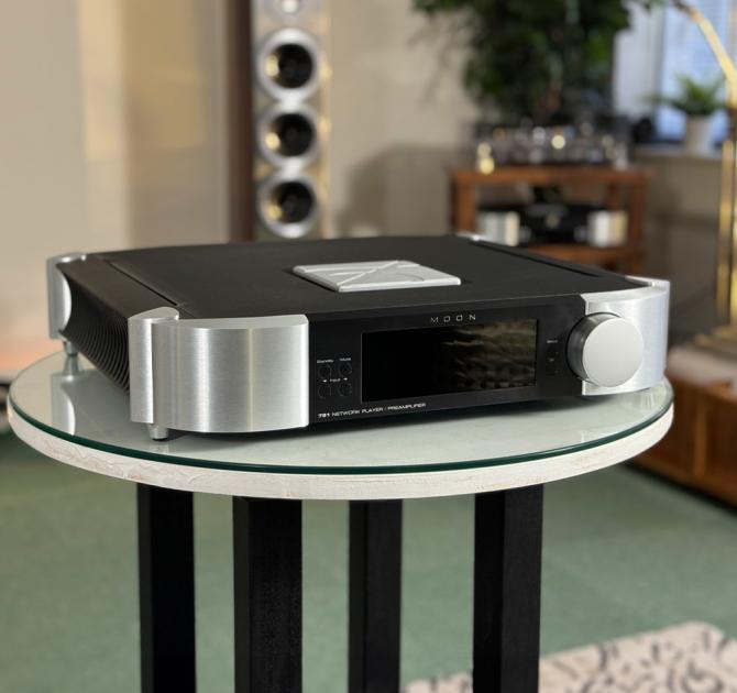 MOON 791 Network Player/Preamplifier on a table in the ripcaster showroom.  An Audiovector floorstanding speaker is in the background along with another piece of MOON equipment and a turntable
