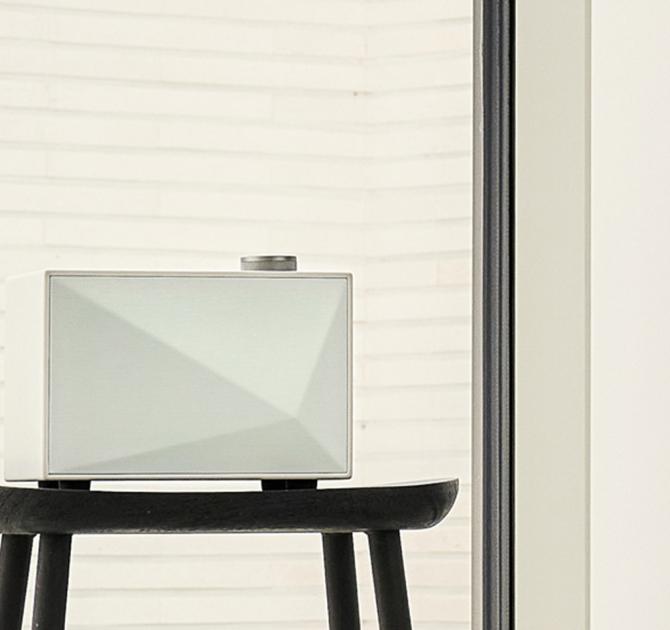 A white Astell & Kern ACRO BE100 Home Audio-Speaker on a black stool