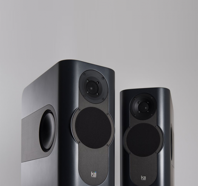 A pair of Kii Three Loudspeakers in a dark grey matt colour