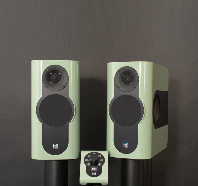 A pair of Kii Three Loudspeakers in high gloss pale green with a matching Kii Controller