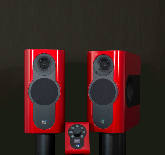 A pair of Kii Three Loudspeakers in gloss red with the Kii controller also in gloss red.