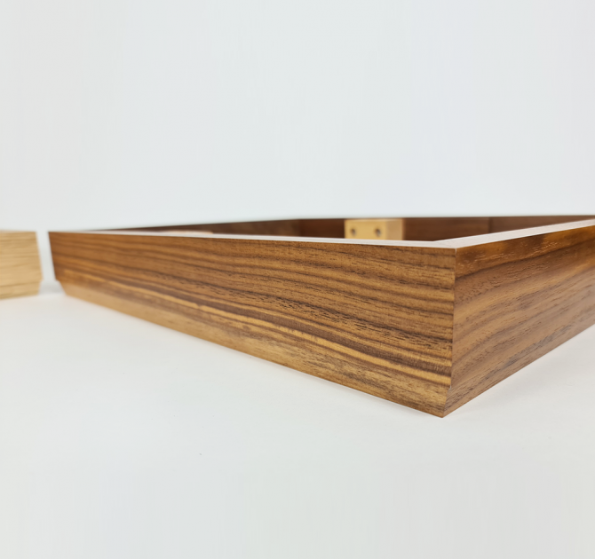 Close-up side view of the walnut plinth with a little bit of oak visible next to it.