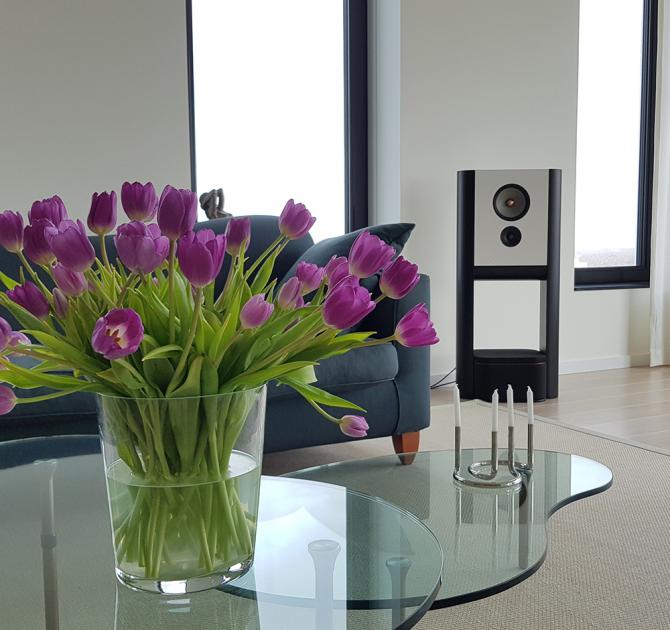 Grimm LS1be Loudspeaker in a living area with a vase of purple tulips in the foreground